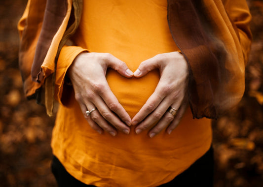 Pregnant lady with hands on her tummy forming a heart