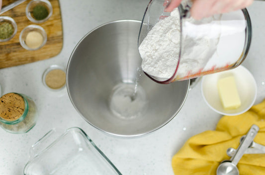 Hand pouring flour into bowl