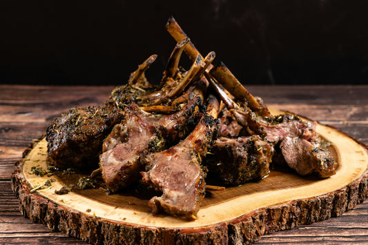 a plate of roasted lamb chops on a wooden table